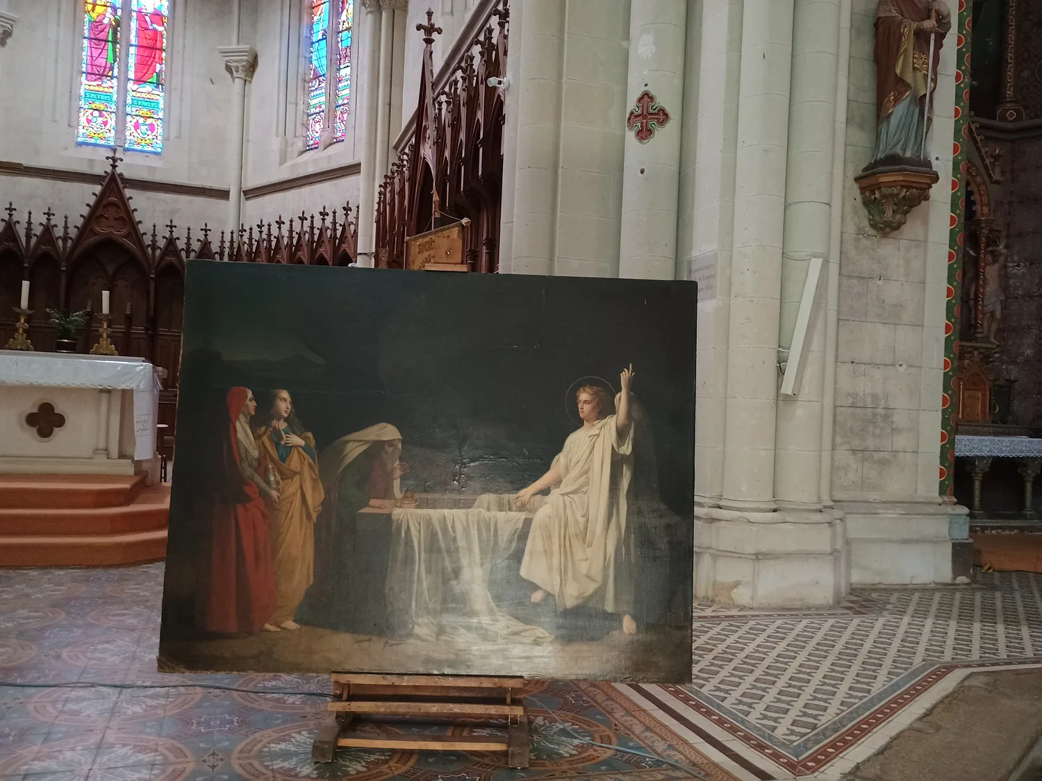 Le tableau « Les Femmes au tombeau » dans l'église de Freigné, devant les vitraux classés de saint Pierre et saint Paul.