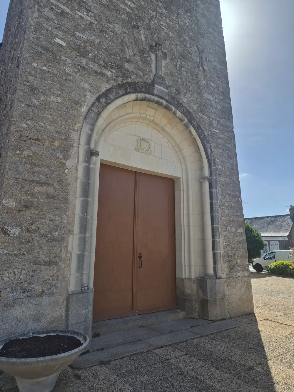 Le portail en plein cintre de l'église de Maumusson et, dans son tympan de tuffeau, l'écu sculpté qui porte la date de 1614.